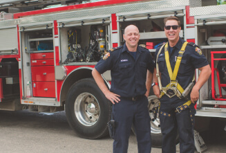 Firefighters smiling by a fire truck